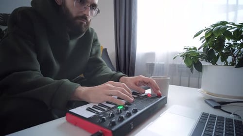 Young Adult Making Music with Electronic Keyboard at Home