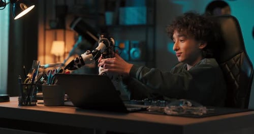 Teen Working on Robot Project at Desk