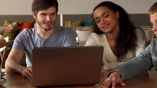 Friends Discuss Something on Laptop at the Cafe