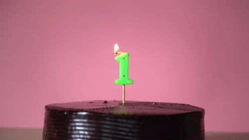 Green Number One Candle on Chocolate Birthday Cake