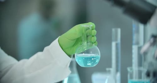 Scientist Mixes Blue Solution in Lab Flask