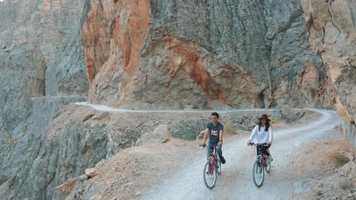 Active Couples Riding Bike on Stone Road