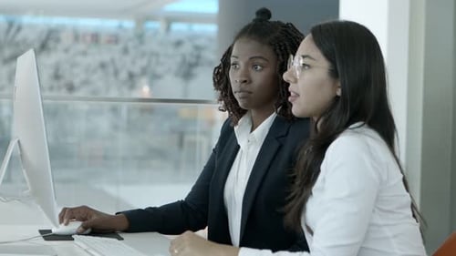 Women Collaborating on Computer in Modern Office