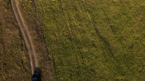 Aerial view, drone view a SUV driving along a dirt road, black suv car driving through a gravel road