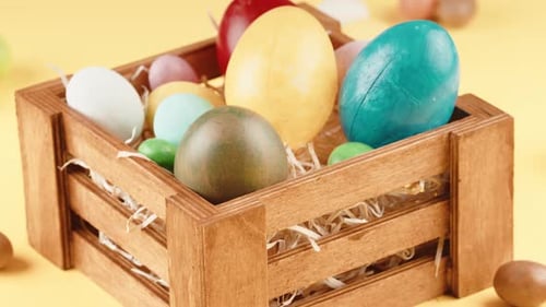 Easter Eggs in Wooden Crate on Yellow Background