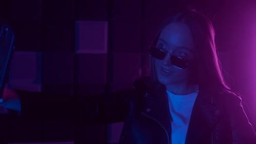 Stylish Young Woman Talks into Smartphone at Night