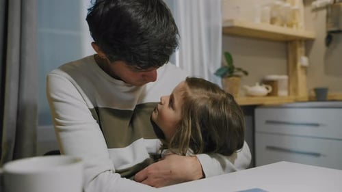 Loving Father Embracing Little Daughter in Kitchen