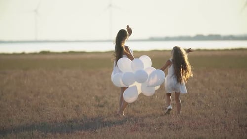Mother with Daughter and Balloons Walk in Nature