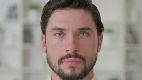 Close Up of Serious Young Man Looking at the Camera