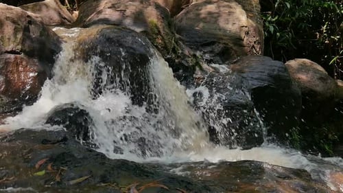 Scenic Waterfall Flowing Over Mossy Rocks