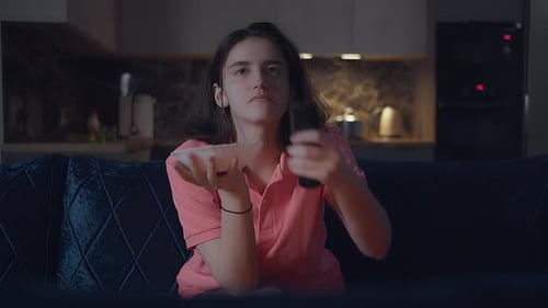 Woman Watching Television at Night and Eating Snacks