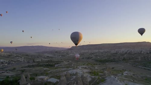 Sunrise and Hot Air Balloons Taking Off Over Valley