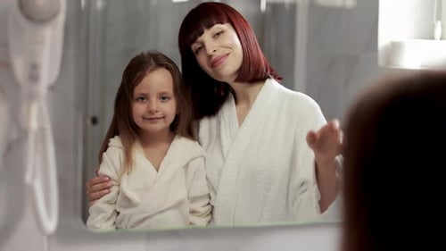 Mother and Child Waving in Bathroom Mirror Reflection