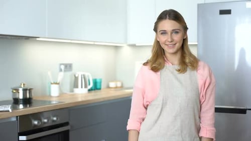 Young Adult Woman Smiling in Modern Kitchen