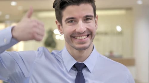 Young Adult Male Gives Thumbs Up and Smiles