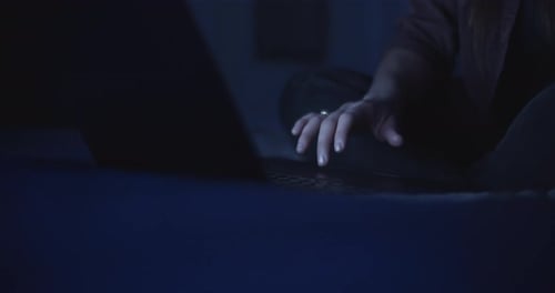 Woman using laptop at night in bed