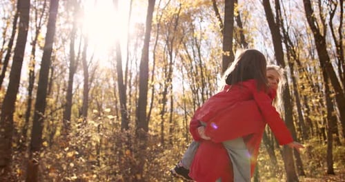 Happy Mother and Child Playing in Autumn Forest
