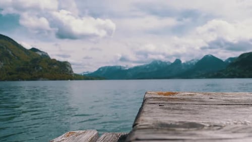 Wooden Pier on the Background of a Mountain Lake and Snowy Alps. Austria. Wolfgangsee Lake