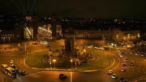 Praça Espanhola (Placa d'Espanya) à noite. Ônibus e carros andando. MNAC em segundo plano. Barcelona, Spa