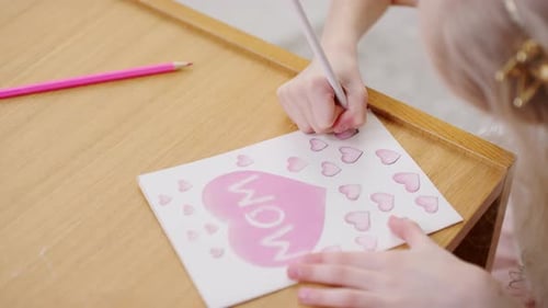 Child Drawing a Card for Her Mother
