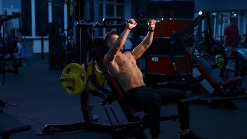 Fitte junge Männer, die Langhanteln heben und in einem Fitnessstudio trainieren.