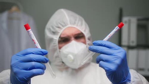 Closeup of PCR Test in Laboratory Doctor Holding COVID19 Coronavirus Swab Collection Kit Wearing PPE