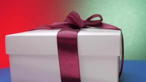 White Festive Box with Purple Ribbon and Bow on Top Rotates
