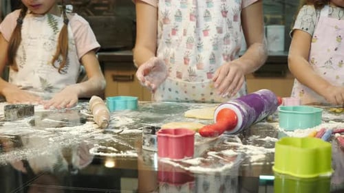 Mädchen spielen mit Teig und backen Kekse