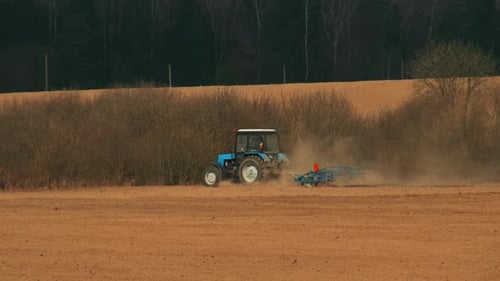 Tractor with a Cultivator Working in an Agricultural Field