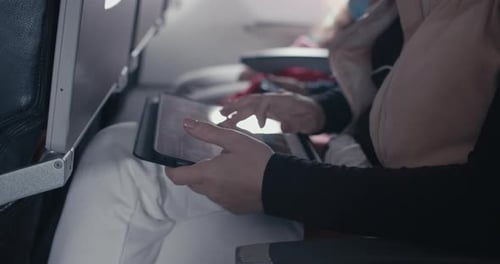 Woman Using Tablet in Airplane Seat