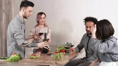 Happy Friends Toasting with Wine on Dinner