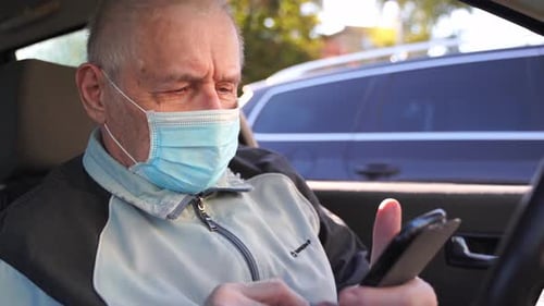 Adult Using Phone and Wearing Medical Mask Driving