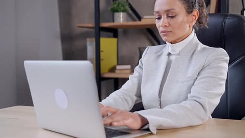 Woman Working on Laptop in Modern Office