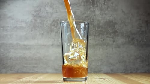 Golden Brown Drink being Poured over Ice