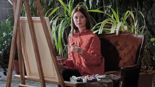 Artist in a Workshop Young Pretty Woman Drawing a Painting Looking in the Camera