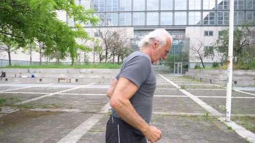 Slow motion shot of senior man jogging in city