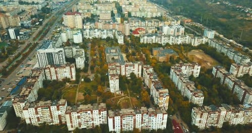 Aerial drone footage of city from above during autumn in a cloudy day.