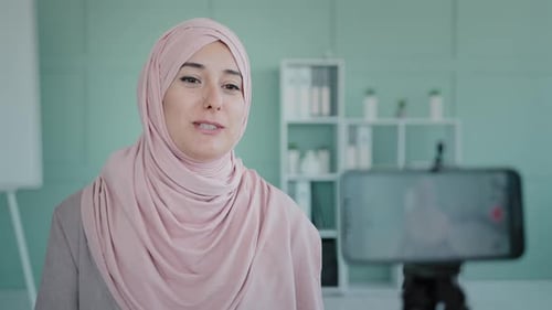 Smiling Arabian Muslim Islamic Ethnic Business Woman Influencer Recording Video Blog Podcast on