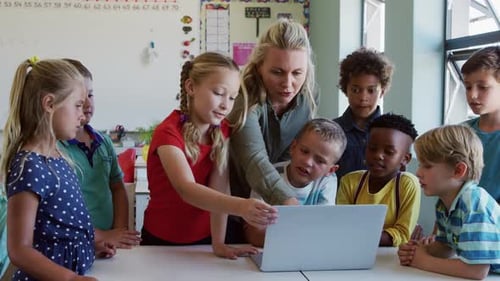 Female teacher and Group of kids using laptop in the class