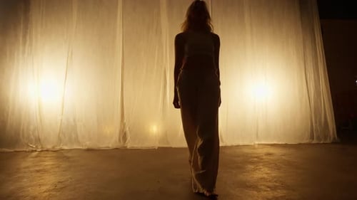 Silhouette of a Professional Dancer Performing in Studio in Soft Warm Lighting