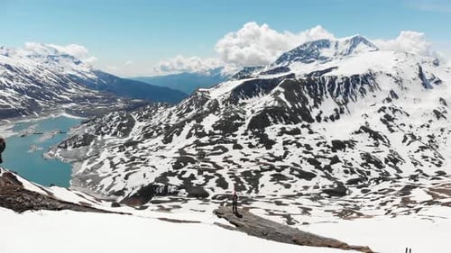 AERIAL: Hiker on mountain top, ski touring mountaineering snow mountain, panoramic view on the alps