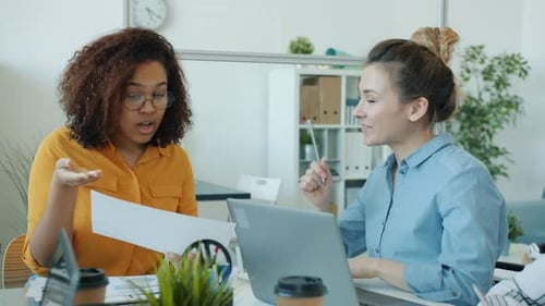 Cheerful Ladies African American and Asian Talking Sharing Ideas Enjoying Cooperation in Office