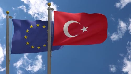 European Union and Turkey Flags Waving Against Blue Sky