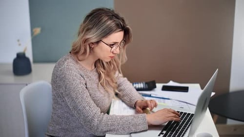 Woman Typing on Laptop in Home Office