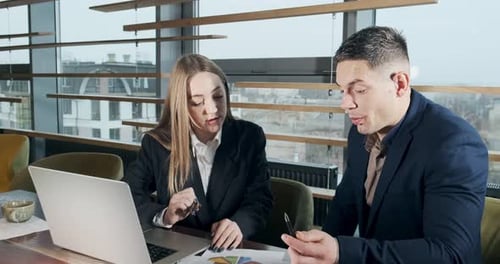 Man and a Woman Discussing Work in the Brightly Lit Modern Office. Concerned Male and Female Working