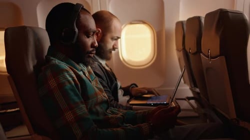 Adults Using Technology On Commercial Airplane