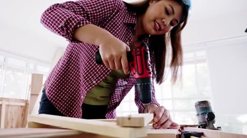 Woodwork and furniture making concept. Stylish craftswoman working in carpentry