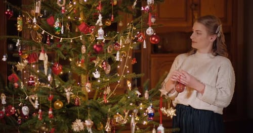 Woman Decorating Christmas Tree with Ornaments