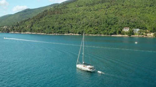Un voilier blanc ou un yacht navigue sur la mer avec de l'eau bleue