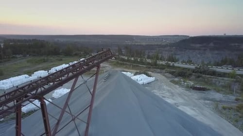 Mining Sector with Grey Rubble Barrow Against Dense Fores
